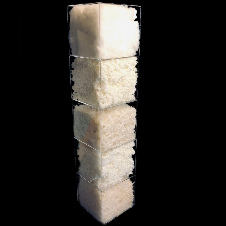 5 cubes black bg 3 clear cubes stacked with cushion fill. Bottom cube is fibre, second cube is memory foam, top cube is feather fill.