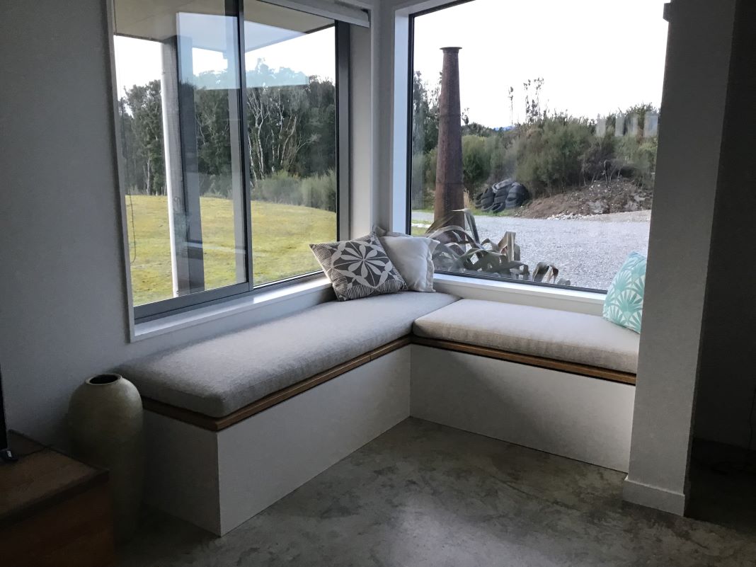 Window seat with upholstered cushions and throw pillows
